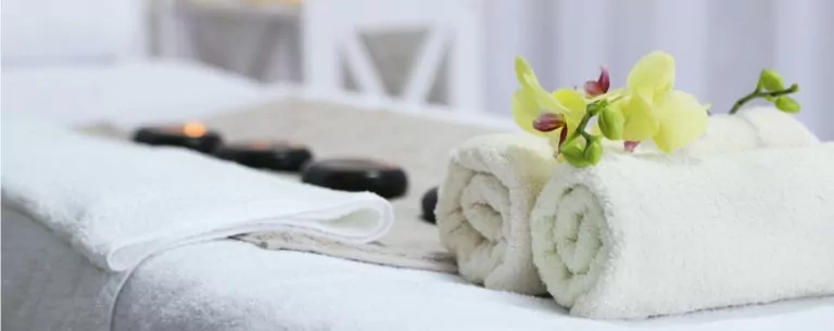 massage therapy setup with towel and hot stones on a massage table