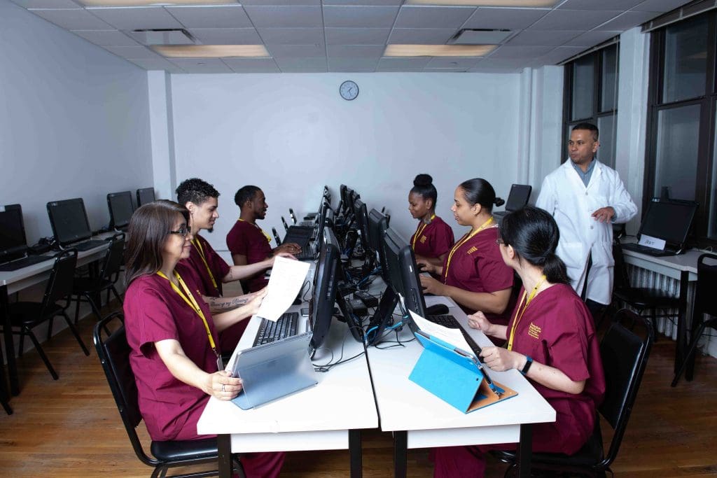 A group of students sitting at computers preparing for a career in medical billing and coding
