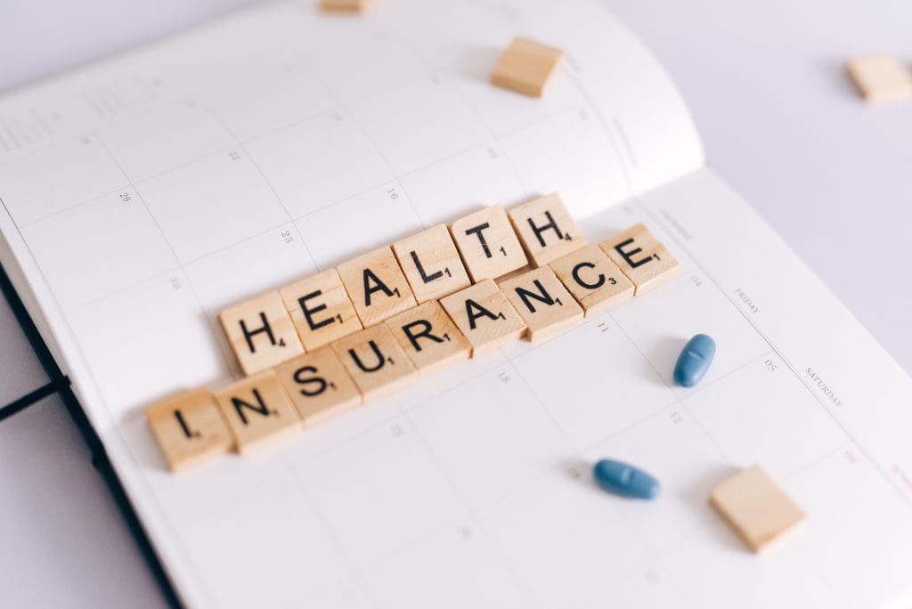 scrabble tiles spelling health insurance.